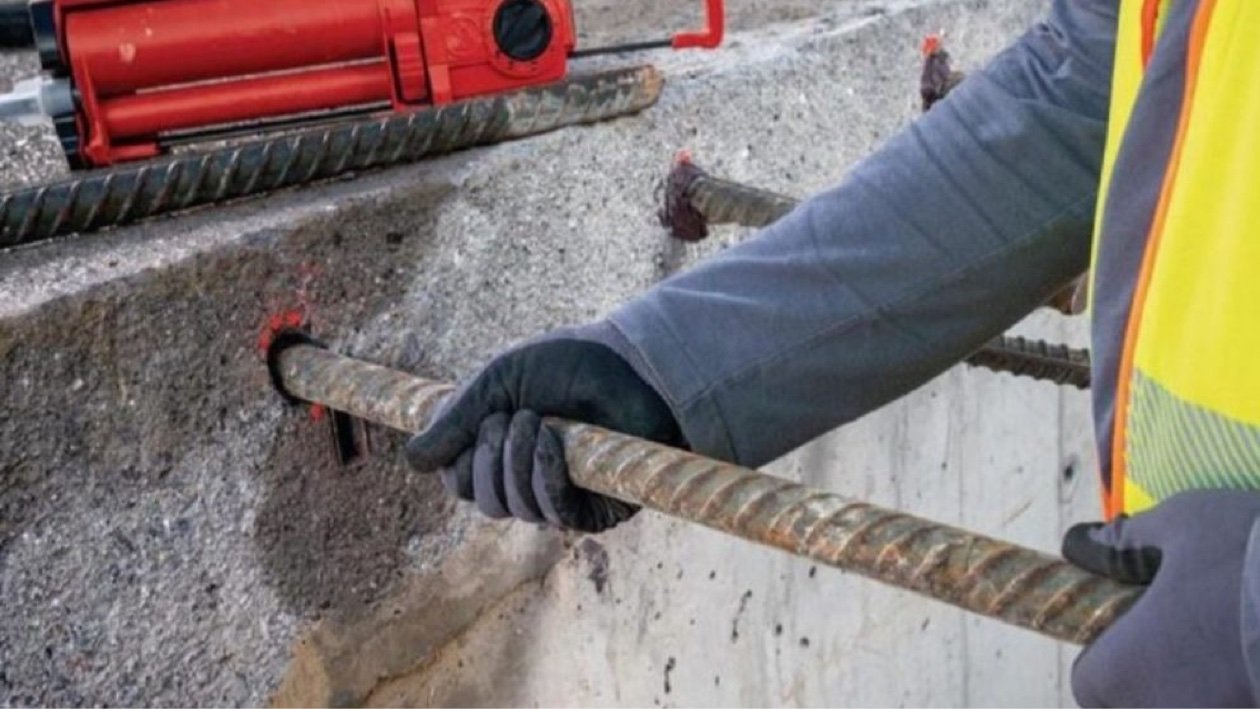 Drilling dowel holes with a rotary hammer next to epoxy-set rebar dowels