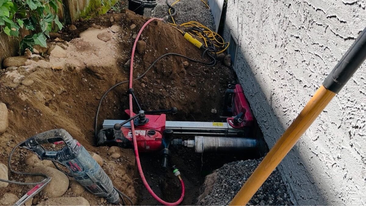 Diamond core drilling rig set up in an excavation for a foundation penetration, Vancouver BC